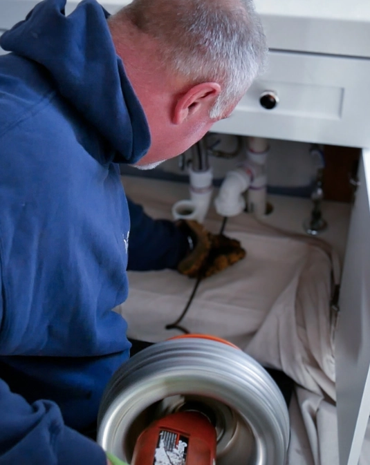 Plumber Working under Sink